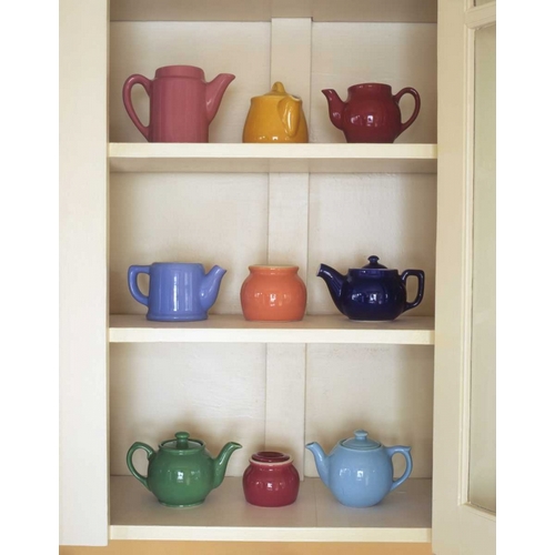 Antique ceramic teapots and sugar bowls in cupboard